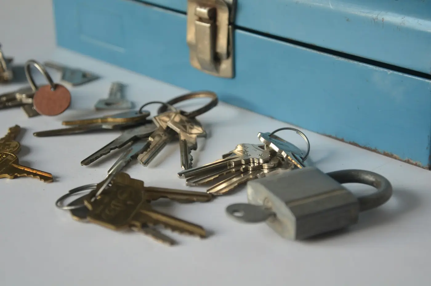 Trousseaux de clés et cadenas posés à côté d'une caisse à outils