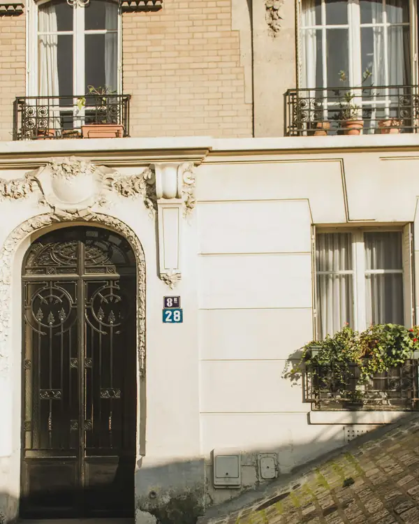 Entrée d'un immeuble ancien avec porte en fer forgé