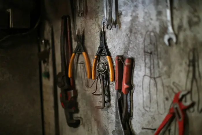 Outils de serrurerie et de mécanique rangés sur un mur d'atelier