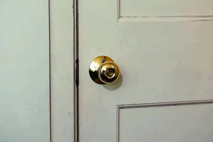 Poignée et serrure d'une porte intérieure blanche