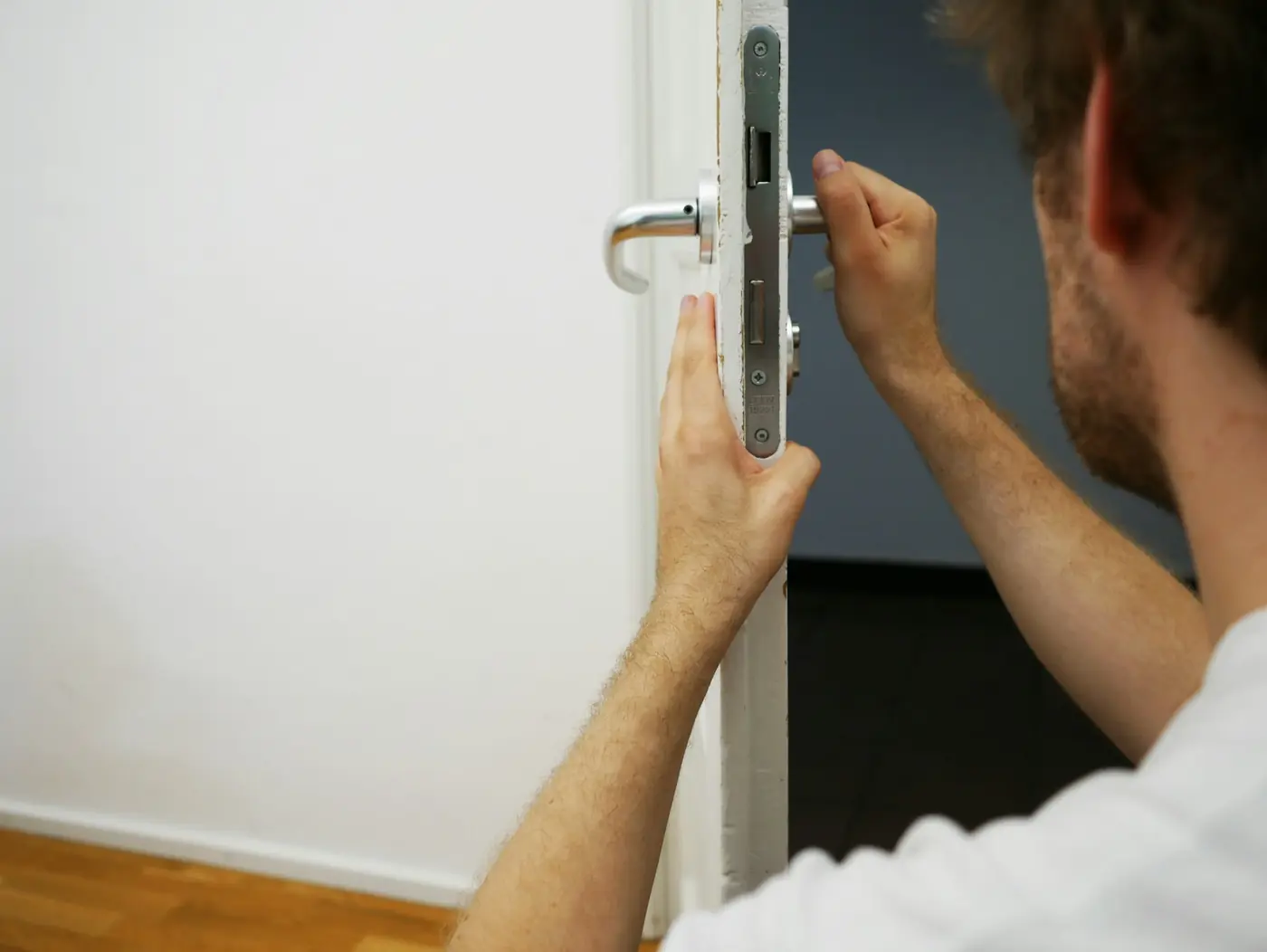 Artisan ajustant la poignée et la serrure d'une porte